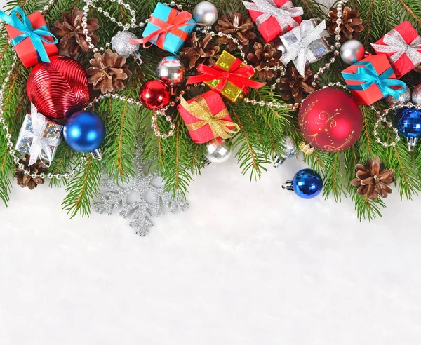 Рождественские украшения на еловой ветке на белом — стоковое фото