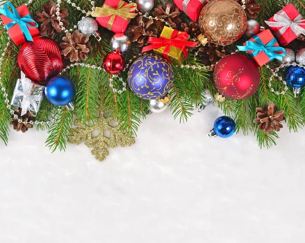 Adornos navideños en una rama de abeto sobre un blanco — Foto de Stock