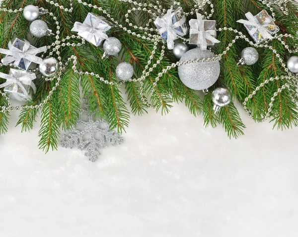 Décorations de Noël en argent sur une branche d'épinette sur un blanc — Photo