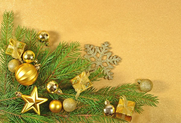 Goldener Weihnachtsschmuck auf einem Fichtenzweig — Stockfoto