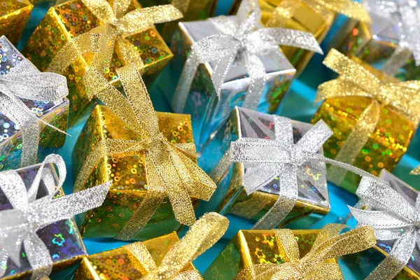 Вид сверху на золотые и серебряные подарки крупным планом на голубом фоне — стоковое фото