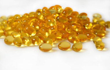 Omega-3 balık yağı kapsülleri beyaz bir arka plan üzerinde yakın çekim şişman.