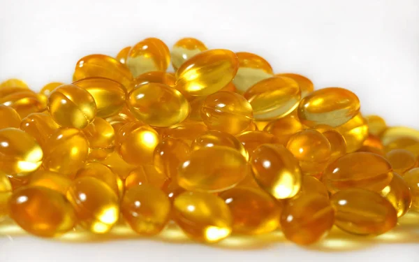 Omega-3 fish fat oil capsules close up on a white background.