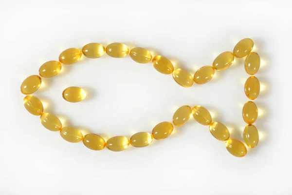 Omega-3 fish fat oil capsules shaped in fish on a white
