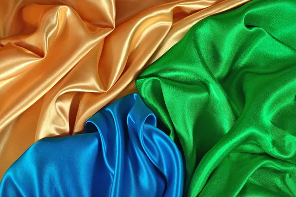 Natural golden, blue and green satin fabric texture