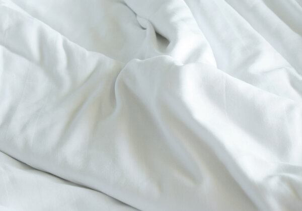 Creased white cloth material fragment as a background