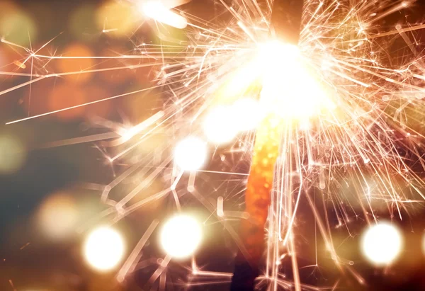 Sparkler on gold bokeh background macro close up — Stock Photo, Image