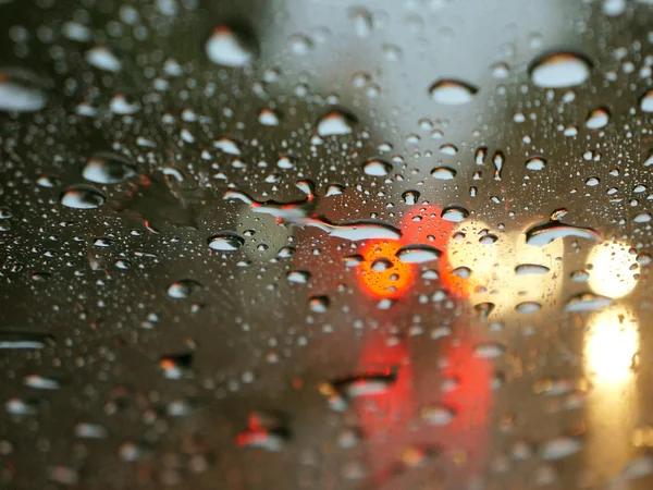 Капли дождя на окно с уличными фонарями — стоковое фото