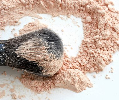Büyük makyaj fırça ile beyaz arka plan üzerinde gevşek kozmetik toz close-up. Yan görünüm