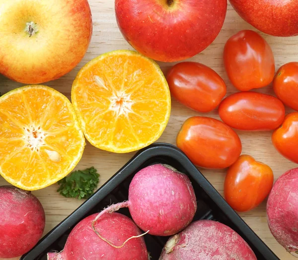 Maçã beterraba laranja e tomates vermelhos na mesa de madeira — Fotografia de Stock