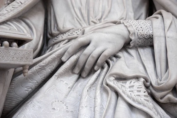 Каменная статуя с рукой на коленях — стоковое фото