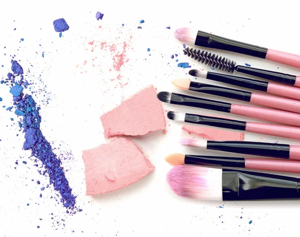 Make-up penselen en geplette oogschaduw op witte achtergrond — Stockfoto