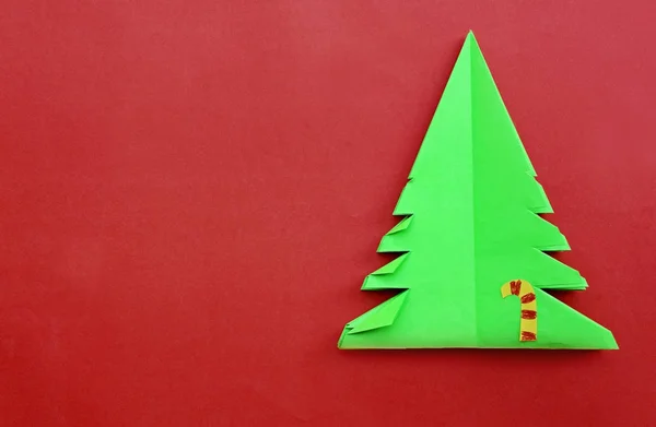 Origami-Weihnachtsbaumpapier auf rotem Hintergrund — Stockfoto