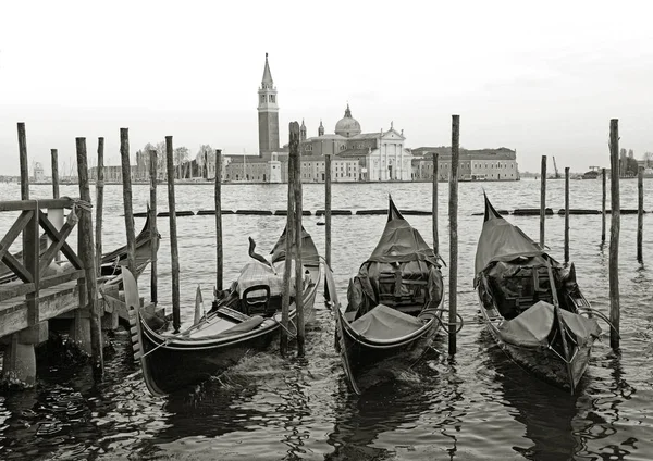 Svart och vitt av gondoler förtöjd av Markusplatsen fyrkantig med San Giorgio di Maggiore-kyrkan i bakgrunden - Venedig, Venedig, Italien, Europa Stockbild