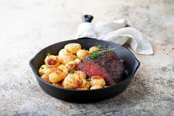 Carne asada y patatas asadas en sartén de hierro fundido —  Fotos de Stock