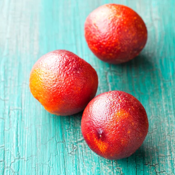 Naranjas de sangre fresca sobre fondo de madera cian —  Fotos de Stock