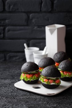 Siyah burger füme somon tartar, salatalık, marul ve krem peynir