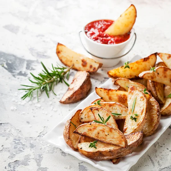 Roasted potato wedges with rosemary and tomato sauce — Stock Photo, Image