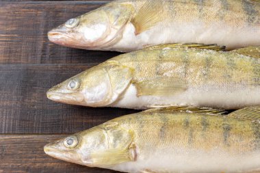 Koyu ahşap bir masada taze donmuş tatlı su balığı. Üst görünüm, kopyalama alanı, minimalist kavram