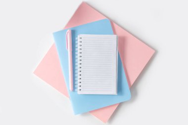 Yazmak için boş bir defter, beyaz bir masa üzerinde kalem olan bir kadın çalışma alanı. Üst görünüm, düz görünüm, kopyalama alanı, minimalizm