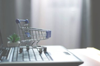 Laptop klavyesinde alışveriş sepeti. Çevrimiçi mağaza, ev dükkanı.