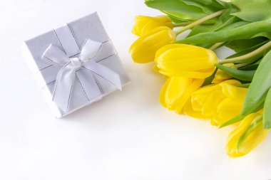 Bir buket sarı lale ve beyaz arka planda not eklemek için bir hediye kutusu.