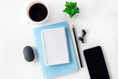 Beyaz bir masa üzerinde açık defter ve kalemle kadın çalışma alanı. Evden çalışmak, blogcu işyeri.