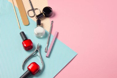 Pembe ve mavi arka planda manikür için araçlar. Tırnak törpüleri, makas ve tırnak cilası üst görüntü. Manikür Salonu, Güzellik Salonu.