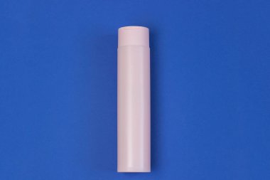 Mavi arka planda serum, jöle ve yüz kremi olan kozmetik pembe bir şişe. Deri kozmetiği, minimalizm. Salon prosedürleri kavramı