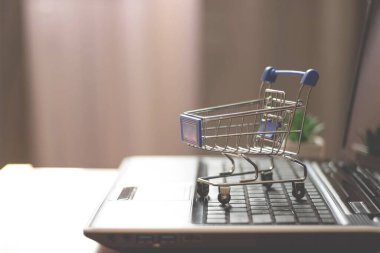 Laptop klavyesinde alışveriş sepeti. Çevrimiçi mağaza, ev dükkanı.