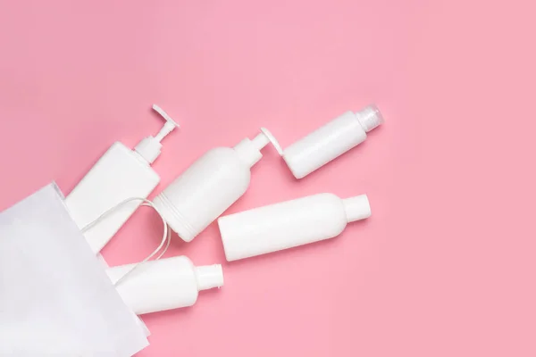 Weiße Kosmetikgläser Fallen Aus Einer Weißen Tüte Auf Rosa Hintergrund — Stockfoto