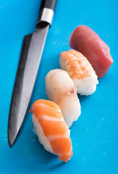 Sushi van de vier verschillende nighiri met een koks mes — Stockfoto