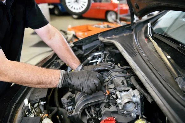 Handskar på händerna av en mekaniker som jobbade på en motor — Stockfoto