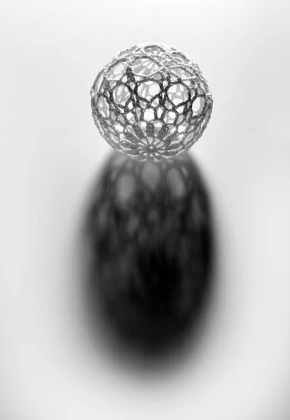 Ball with openwork shell casting shadow — Stock Photo, Image