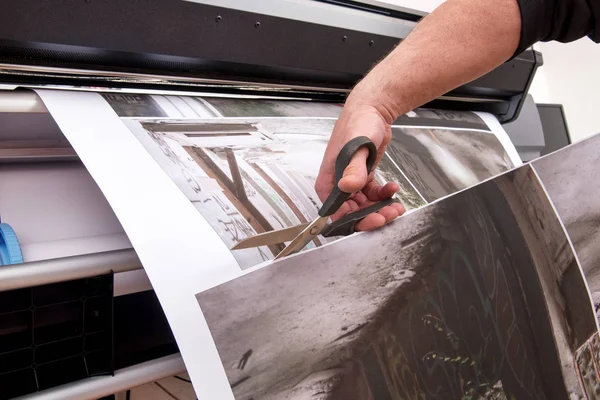 Вирізання друкованих зображень ножицями — стокове фото