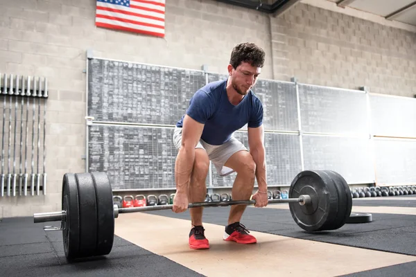 Atleta che inizia un deadlift in una palestra crossfit — Foto Stock