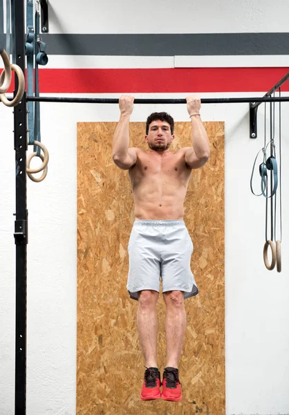 Fit athlete doing a pull up on a horizontal bar