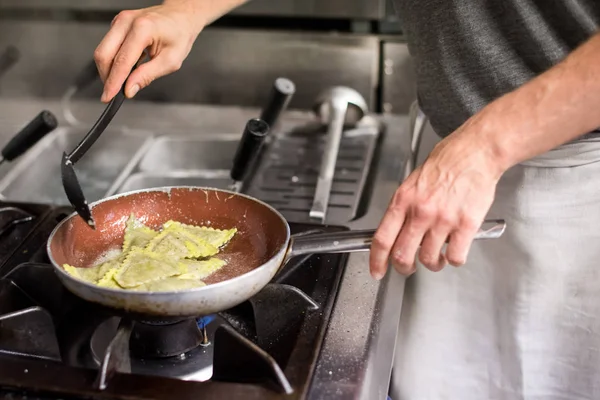 Cocinero revolviendo pasta de ravioles en sartén — Foto de Stock