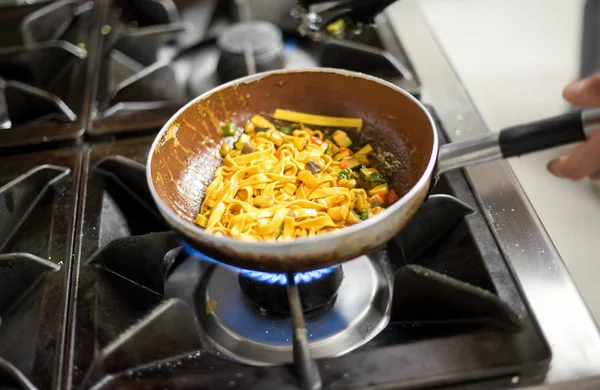 Cooking tagliatelle pasta on burners — Stock Photo, Image