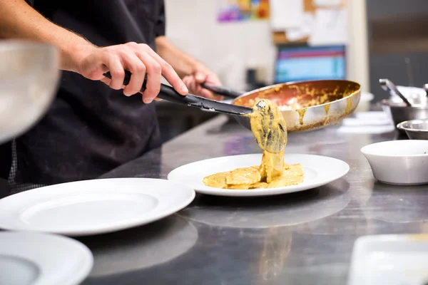 Chef que sirve pasta italiana en una cocina de restaurante — Foto de Stock