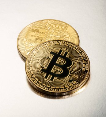 İki altın Bitcoins bir ışık gri arka plan