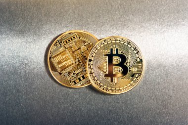 İki altın yansıtıcı bir arka plan üzerinde Bitcoins