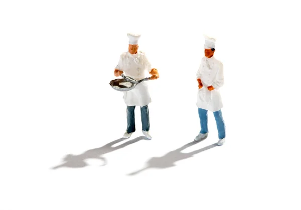 Beeldjes van chef-koks tegen witte achtergrond — Stockfoto