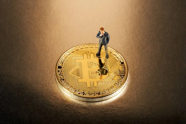 Miniatur-Geschäftsmann auf einem Bitcoin — Stockfoto