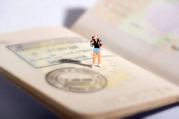 Миниатюрная фигура путешественника на паспорте — стоковое фото