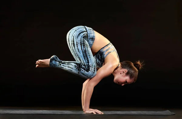 Mujer demostrando una pose de cuervo en yoga —  Fotos de Stock