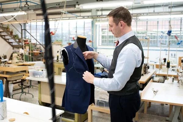 Tailor working over mannequin with jacket — Stock Photo, Image