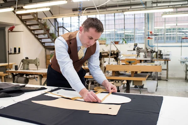 Skräddare arbeta med papper mönster på ny jacka — Stockfoto