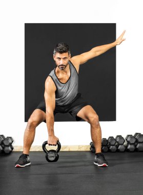 Kettlebell ağırlığıyla egzersiz yapan bir adam.