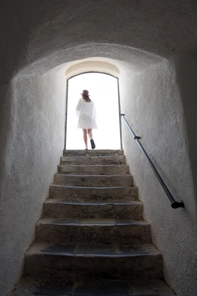 Mujer saliendo a la luz del día por las escaleras — Foto de Stock